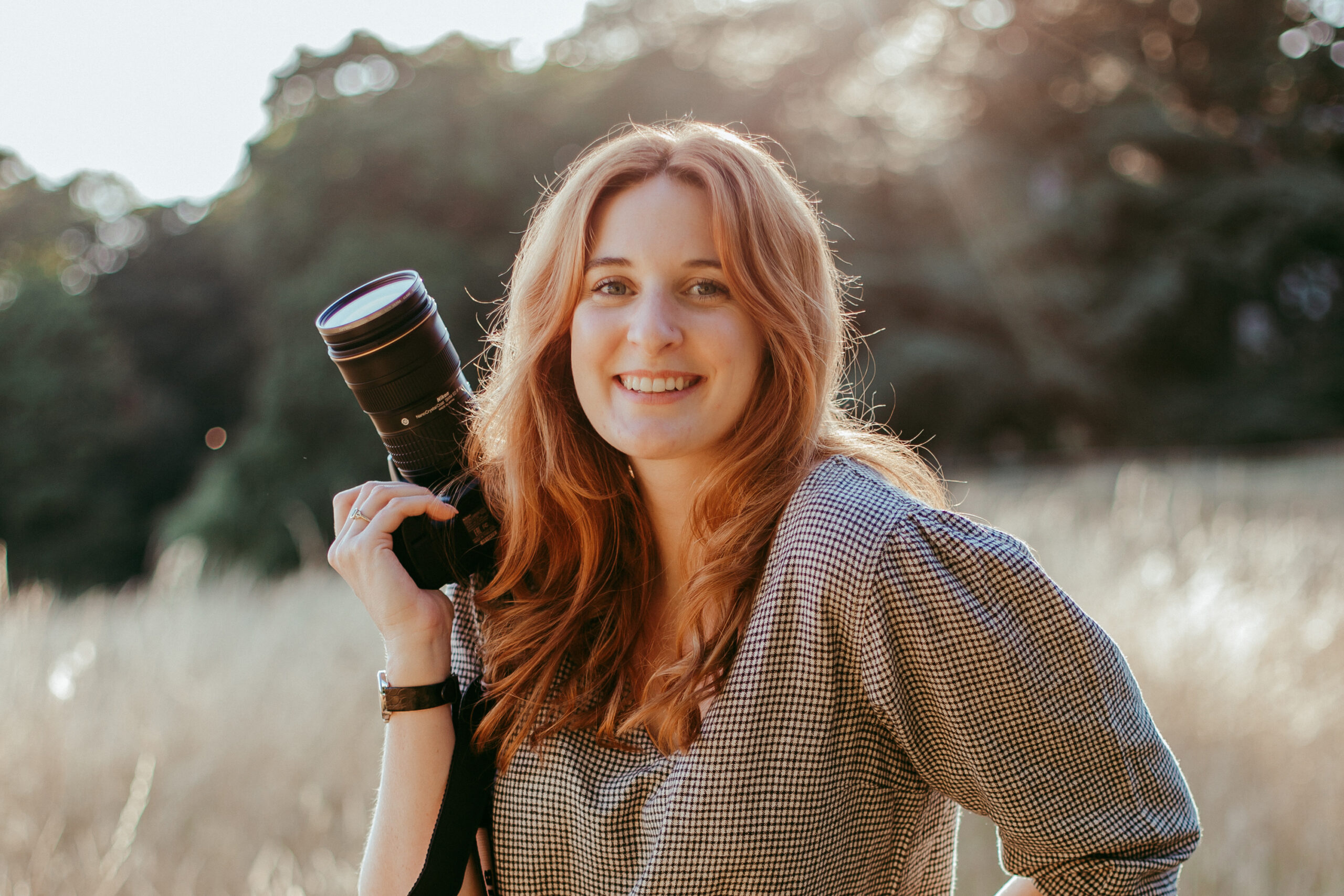 Woman holding a camera and smiling